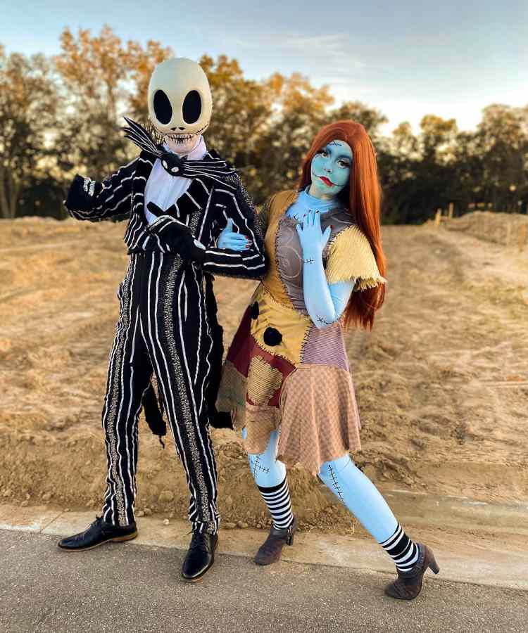Fantasia de casal para o Halloween: Jack Skellington e Sally do filme O Estranho Mundo de Jack. Ele usa a máscara do personagem e a roupa preta, enquanto ela está pintada de azul, com cicatrizes pretas e vestido de retalhos 