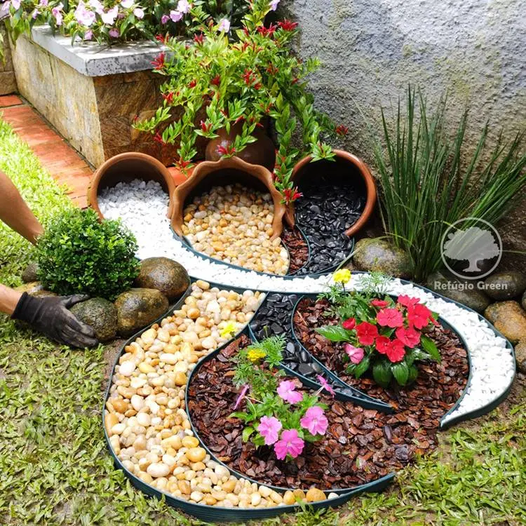 Jardim criativo com vasos e pedras derramando e flores