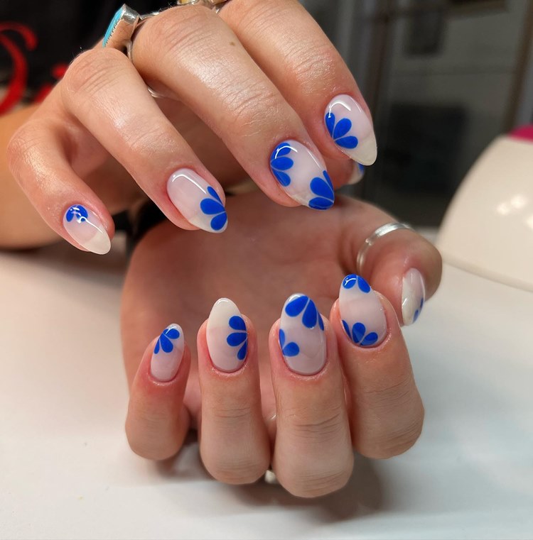 unha branca com decoração de pétalas em azul-médio