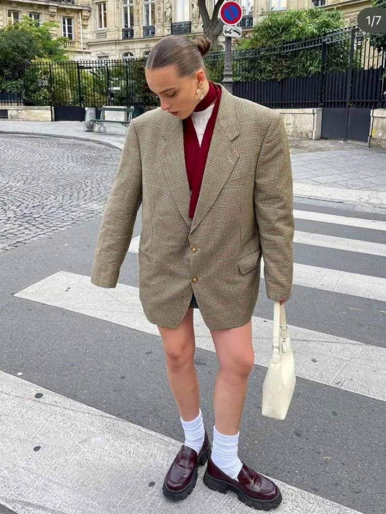 Mulher usando mocassim com blazer xadrez