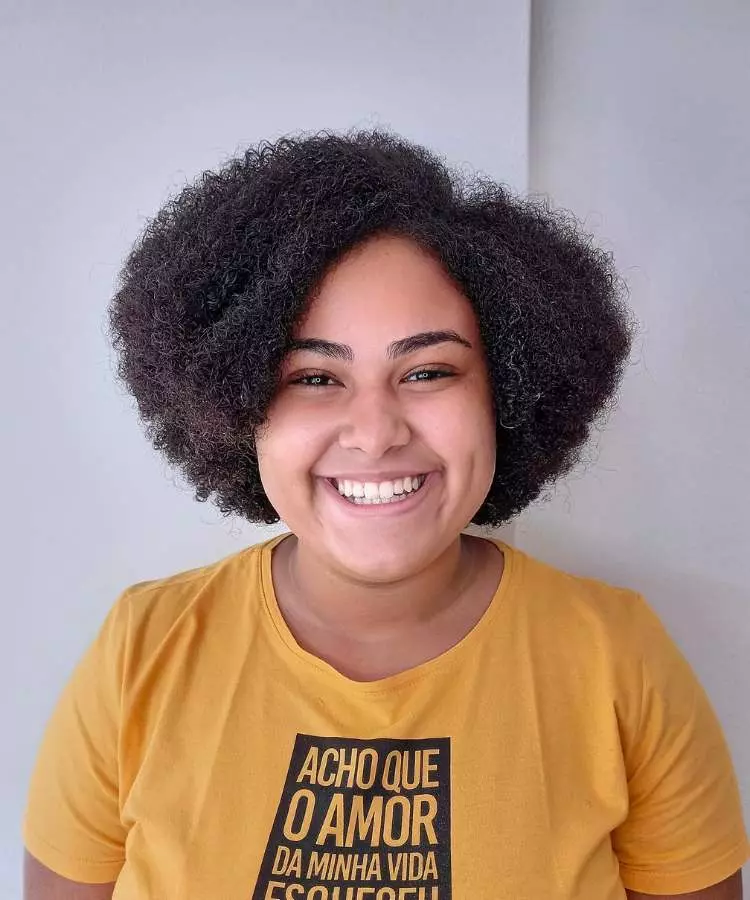 Corte assimétrico mulher com cabelo castanho escuro crespo
