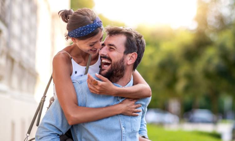 Casal sorrindo felizes em um relacionamento aberto.