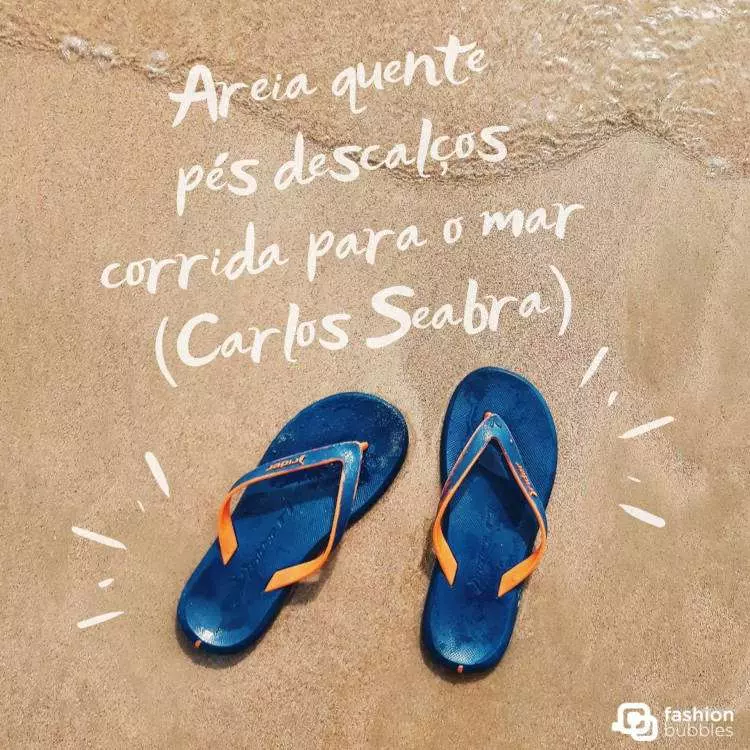 Foto de chinelo azul na areia e frase: Areia quente
pés descalços
corrida para o mar. (Carlos Seabra)