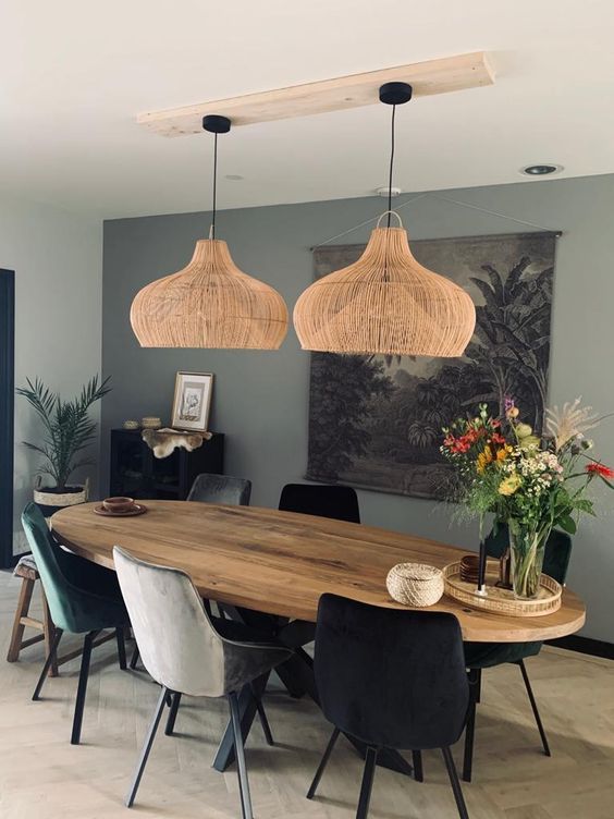 Luminária de palha para decoração de outono, sobre mesa de madeira com cadeiras pretas