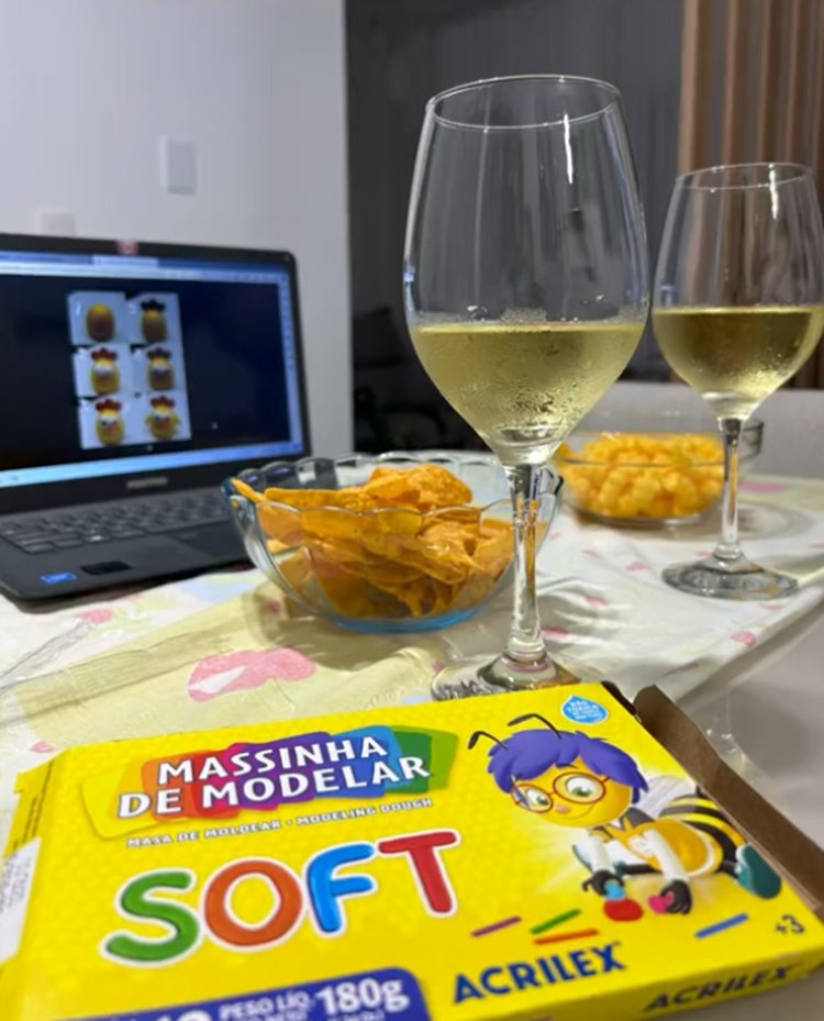 Print de vídeo do Tik Tok: mesa com computador, taças, potes de vidro com doritos e caixa de massinha de modelar para Trend noite da massinha 
