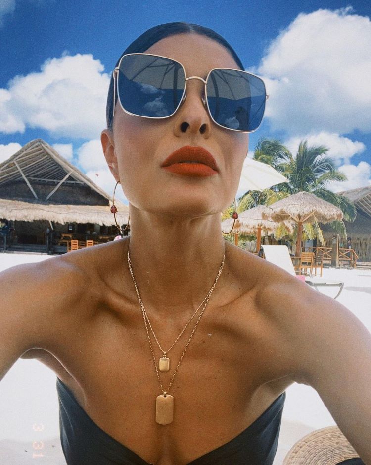 Juliana Paes na praia com argolas e óculos oversized e correntes
