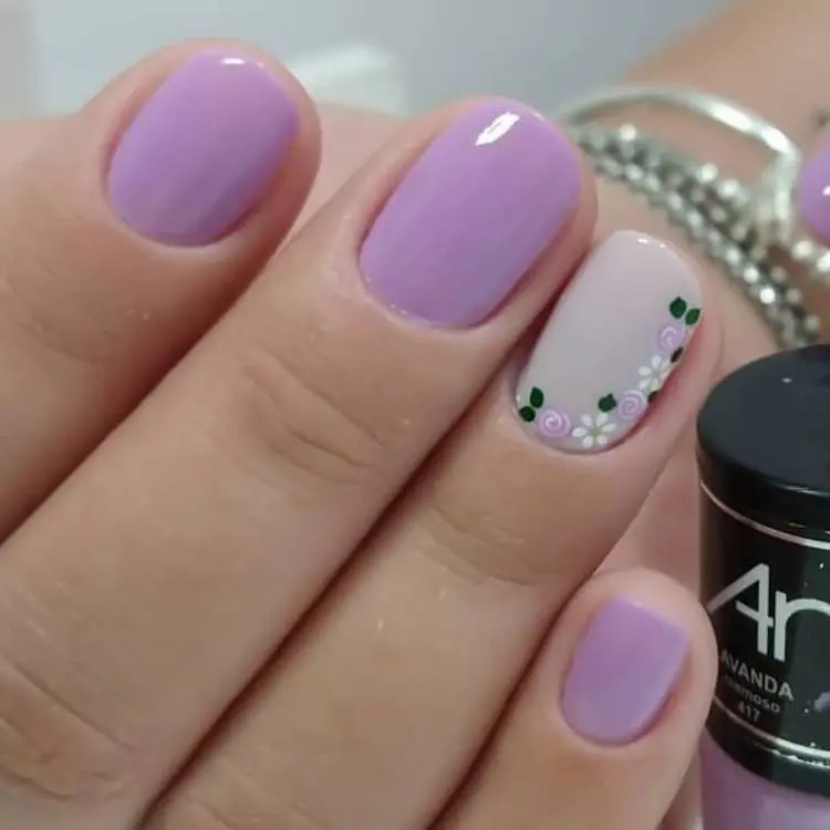 unhas curtas em lilás com flores no anelar
