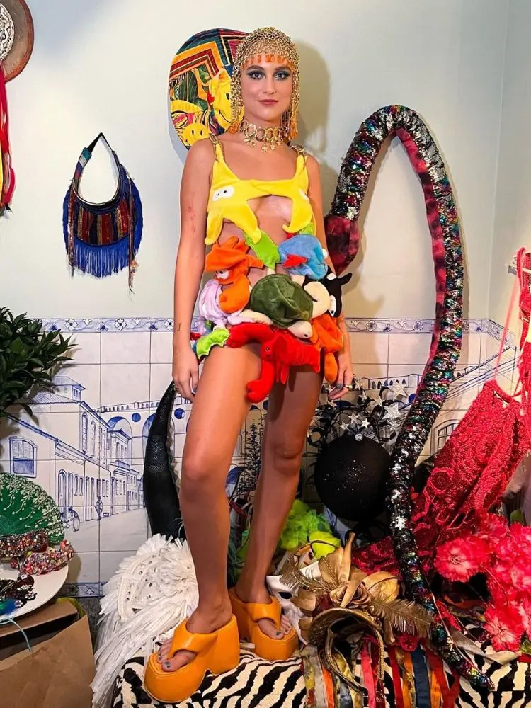 foto de mulher usando vestido feito com bichos de pelúcia costurados, na tendência maximalista para o Carnaval 2024