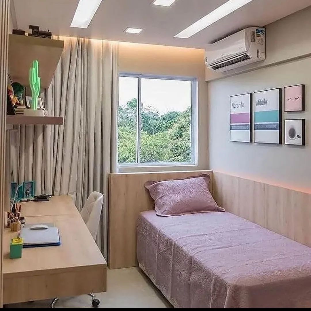 Quarto de solteiro com mesa de estudos.