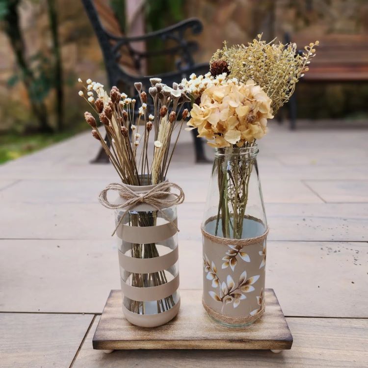 Arranjo com flores em potes de vidro. 