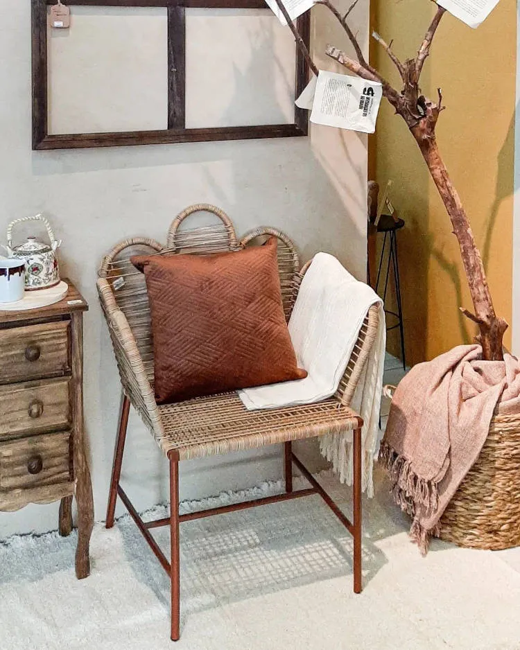 Hall de entrada com decoração de outono, com cadeira, almofada marrom, cômoda vintage, planta seca e mais 