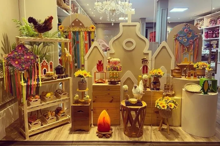 Vitrine em tons de marrom com girassóis, galinha, chita, fogueira de enchimento