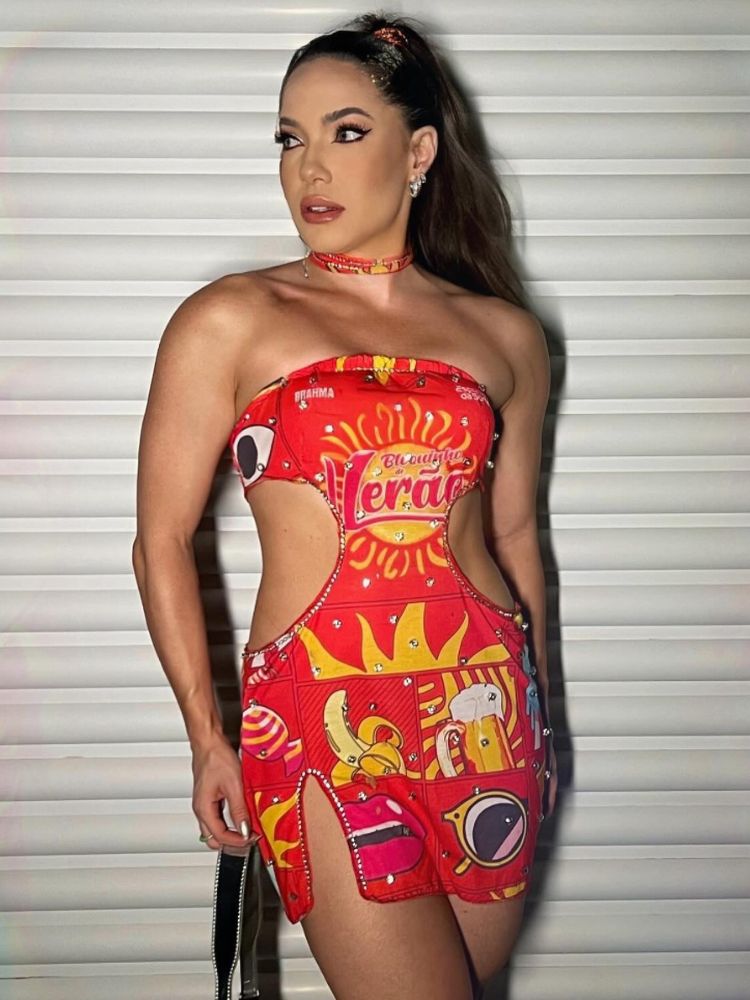 Mulher de pele clara com abadá vermelho customizado em vestido sem alça com fenda lateral e recortes na cintura 