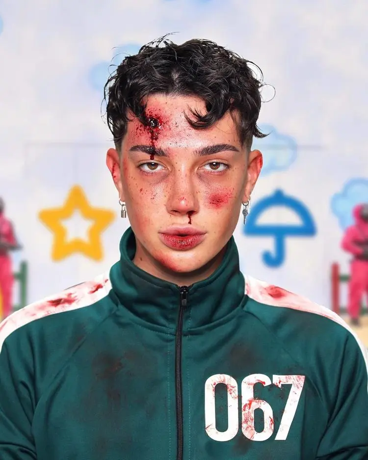 homem com maquiagem da série Round 6, com jaqueta da série e sangue falso no rosto