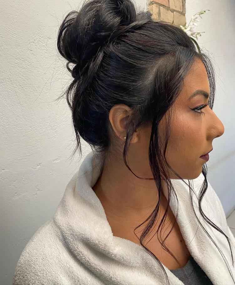 mulher com coque alto despojado em cabelo preto