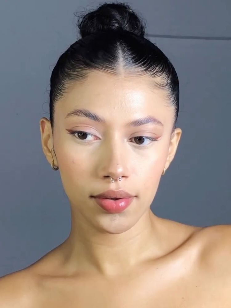 Mulher de pele clara usando coque alto com gel