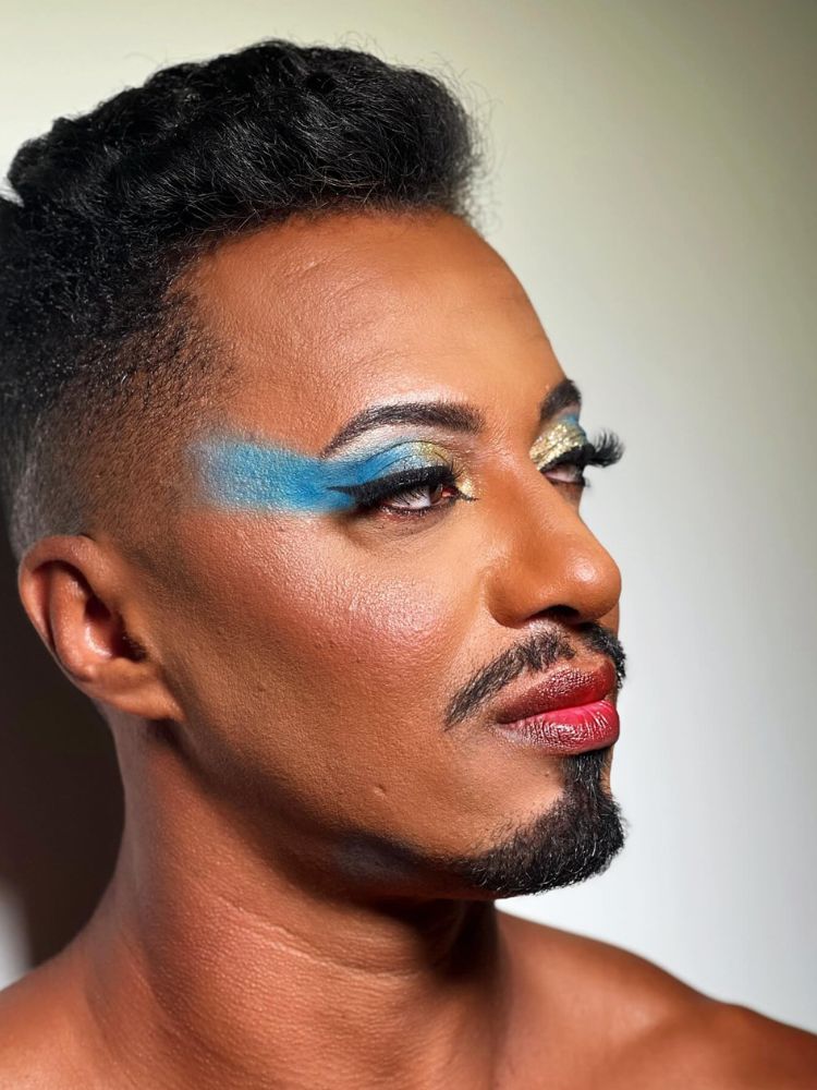 Homem de pele negra com sombra azul e dourada