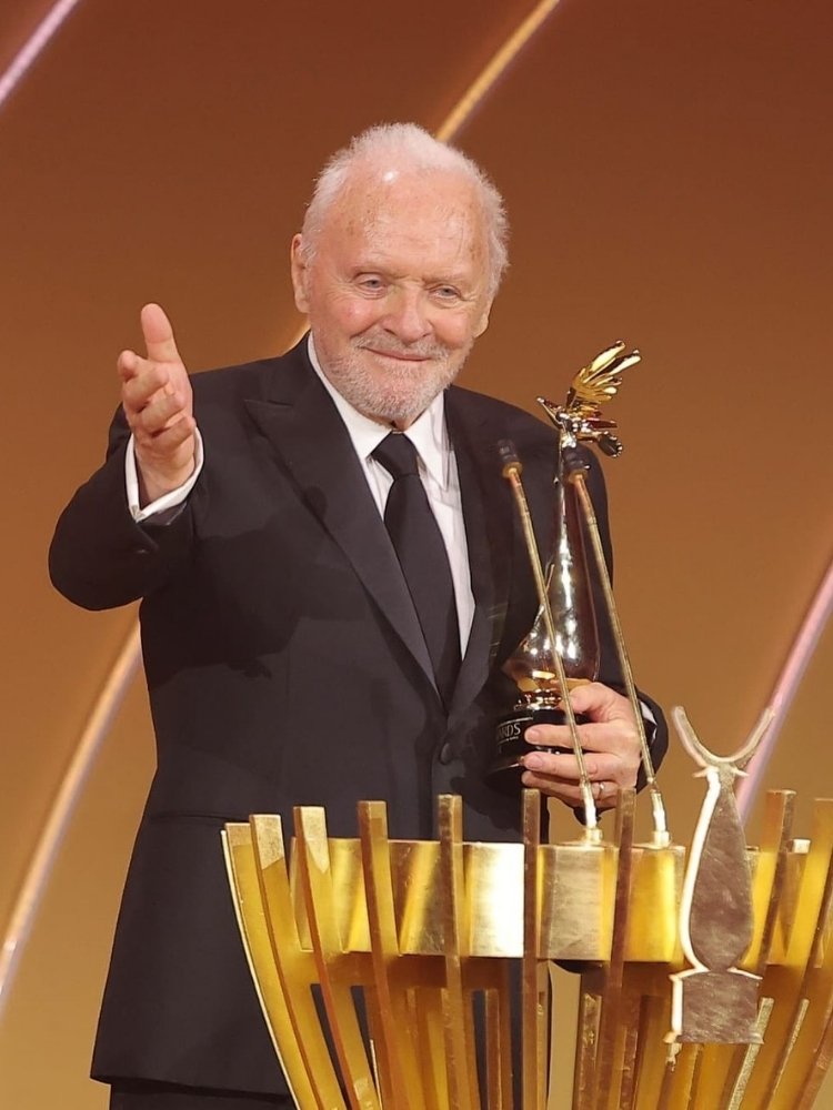 Anthony Hopkins de terno recebendo prêmio