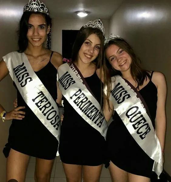 Foto de três mulheres de vestido preto com faixa de miss, "teriosa", "perimenta" e "quece".