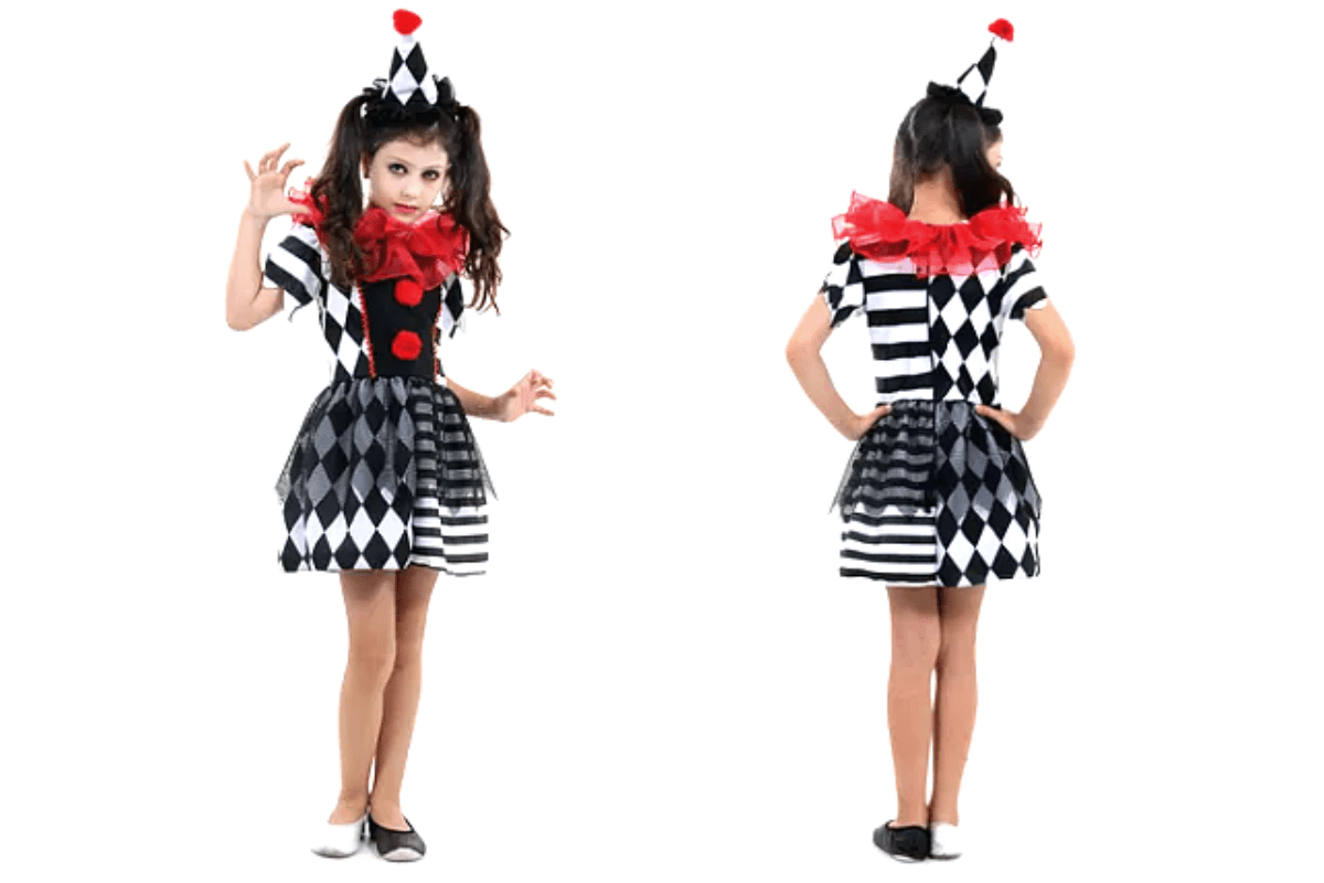 menina fantasiada de palhaça. A fantasia consiste em um chapéu preto e um vestido branco com preto. Seus sapatos, um é branco e o outro preto. A menina ainda está maquiada como um palhaço