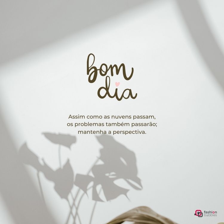 Imagem minimalista com fundo branco. Texto no centro diz: "bom dia" com um coração pequeno. Abaixo, uma mensagem motivacional: "Assim como as nuvens passam, os problemas também passarão; mantenha a perspectiva." Sombras de folhas decoram o fundo.