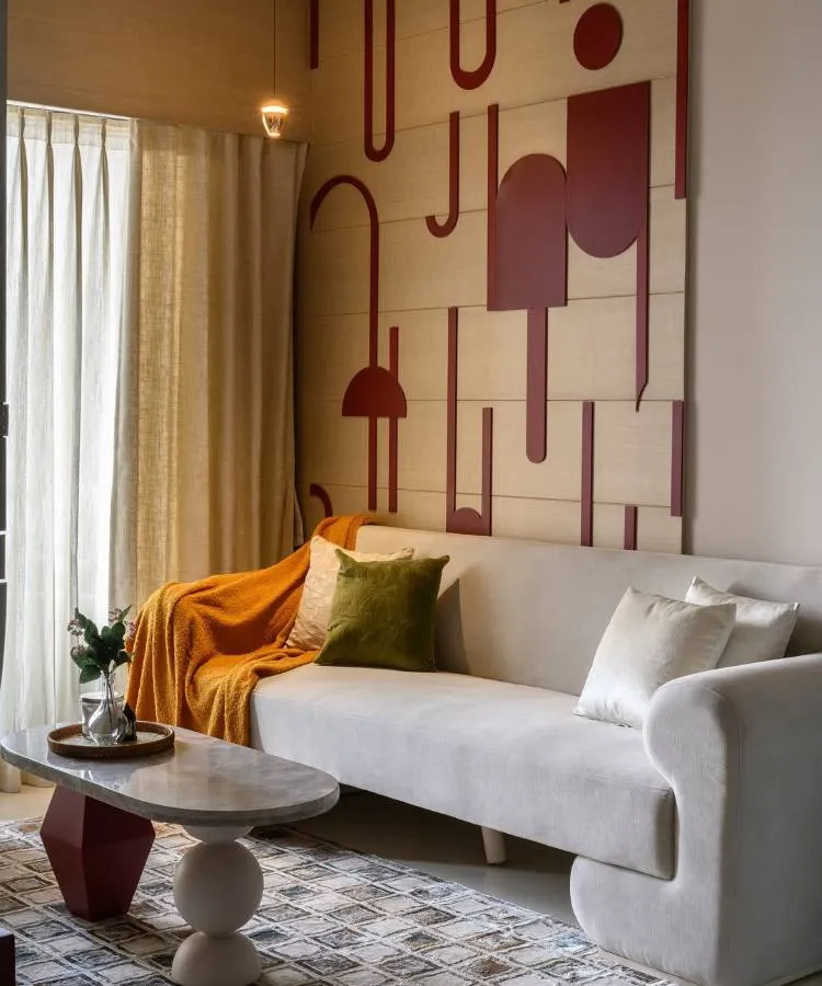 Uma sala moderna com sofá claro, manta laranja e almofadas para sala verde-oliva e creme. A parede destaca-se com painéis de madeira e formas geométricas em tom terroso. Uma mesa de centro de mármore e base escultórica complementa o ambiente elegante. Cortinas neutras completam a decoração.







