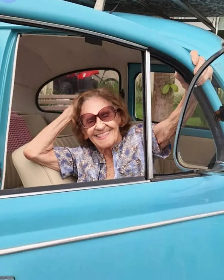 A atriz de óculos de sol em fusca azul.