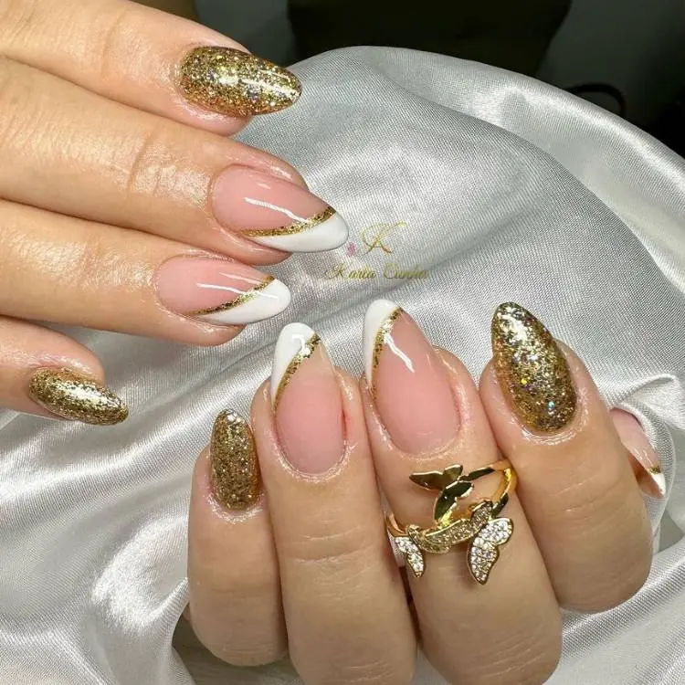 unhas almonf com base transparente meia francesinha branca e dourada e unhas douradas