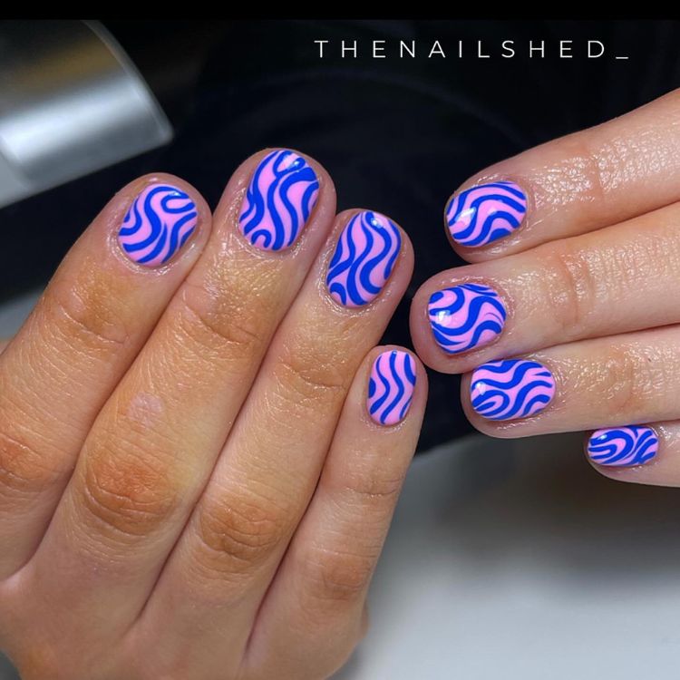 unhas curtas rosas com detalhes abstratos em azul