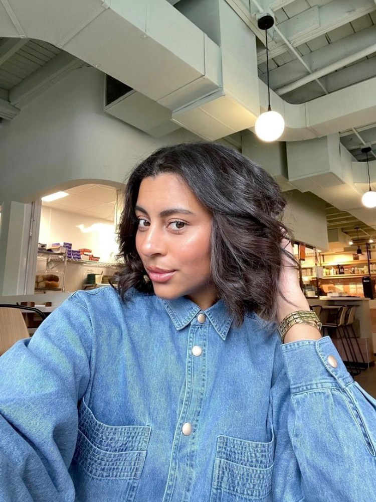 Mulher de pele morena com cabelo castanho curto e repicado