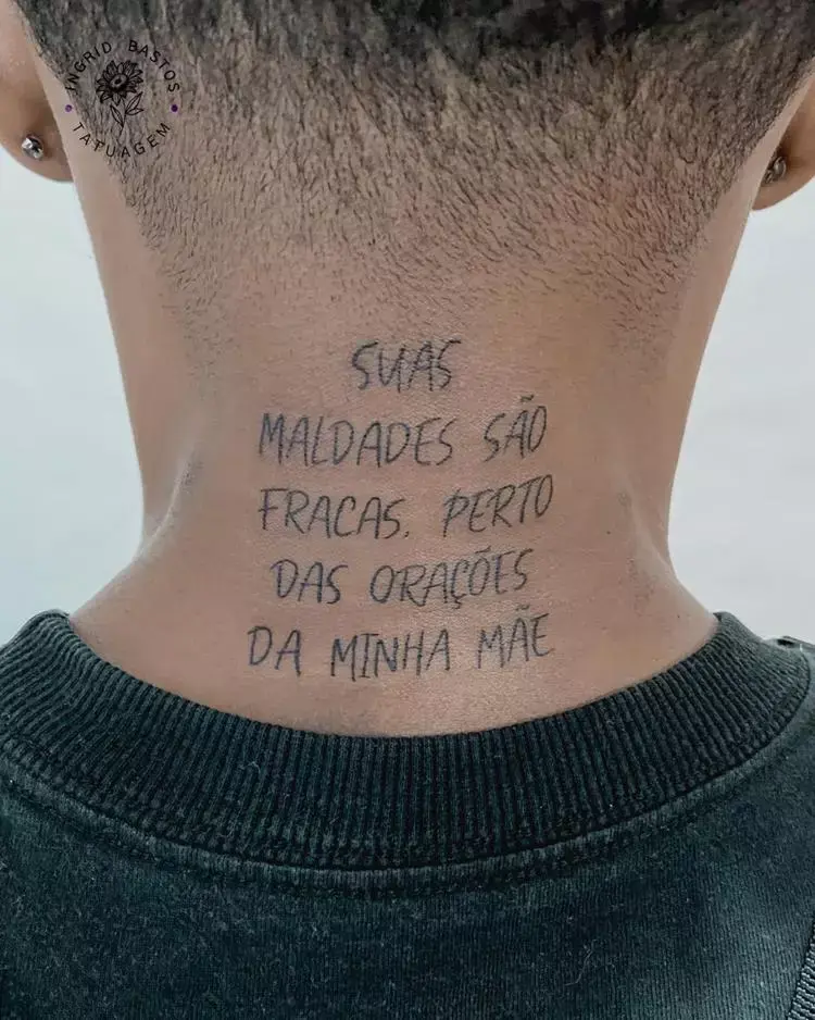 tatuagem escrita Suas maldades são fracas perto das orações da minha mãe na nuca