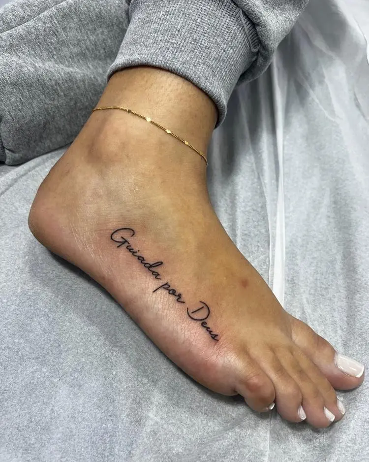 tatuagem escrita Guiada por Deus no pé