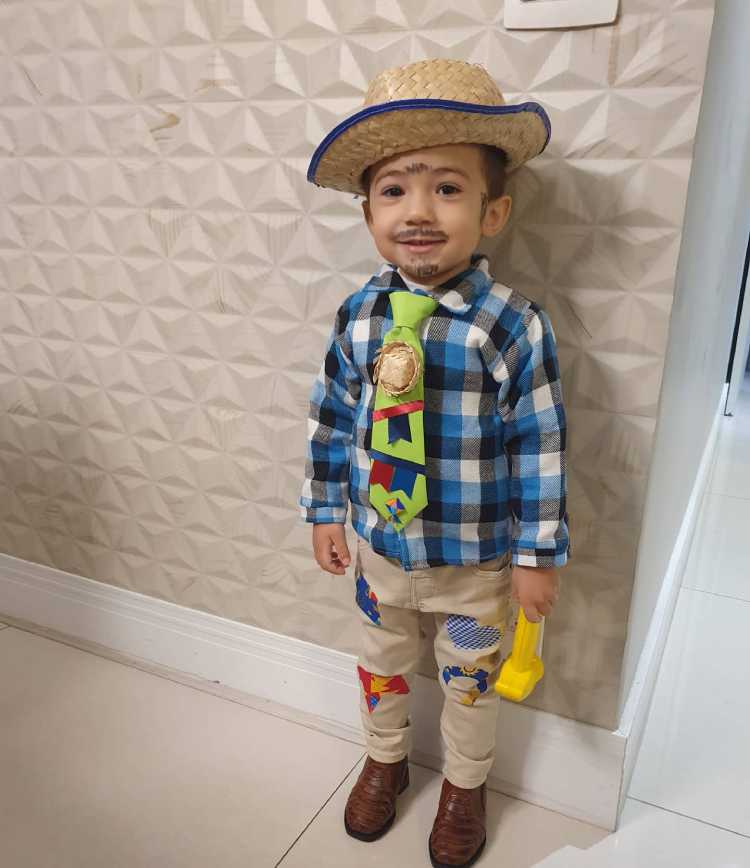 menino com roupa xadrez típica de festa junina