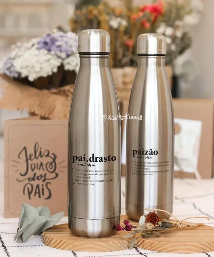 Duas garrafas térmicas de metal com inscrições personalizadas, ao lado de uma caixa com a frase “Feliz Dia dos Pais”.