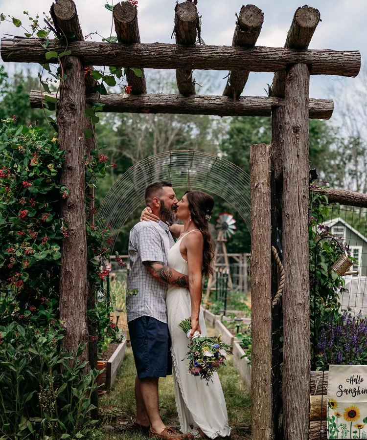 Noivos se beijando em pergolago de jardim