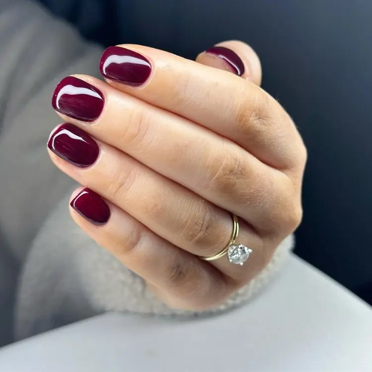 Mão de pele clara com unhas curtinhas arredondas vinho 