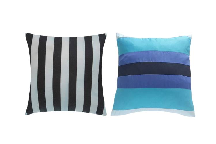 Almofada listrada de branco e preto e almofada listrada de azul e preto. 