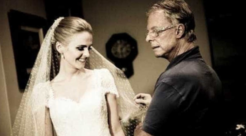 Foto do estilista brasileiro Guilherme Guimarães a segurar o véu de uma modelo vestida de noiva Foto do estilista brasileiro Guilherme Guimarães a segurar o véu de uma modelo vestida de noiva