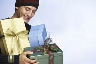 Homem segurando vários presentes.
