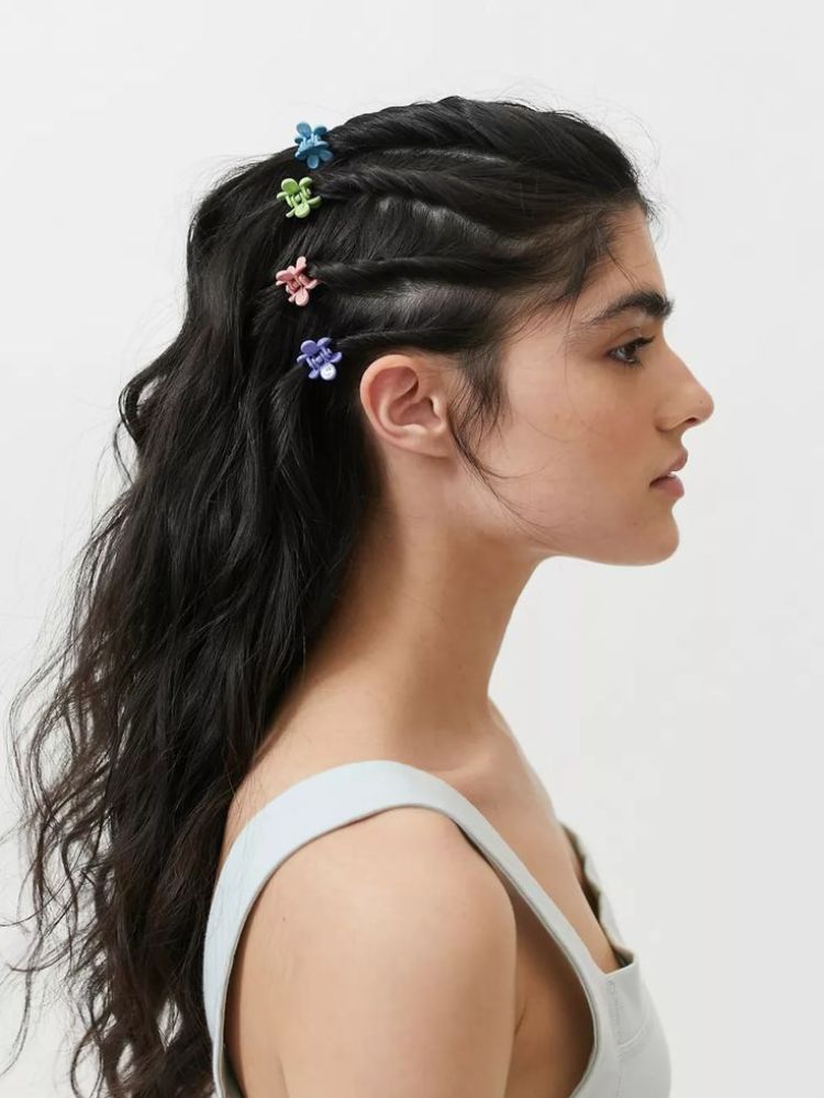 Mulher de pele clara com cabelo solto com mini presilhas coloridas 