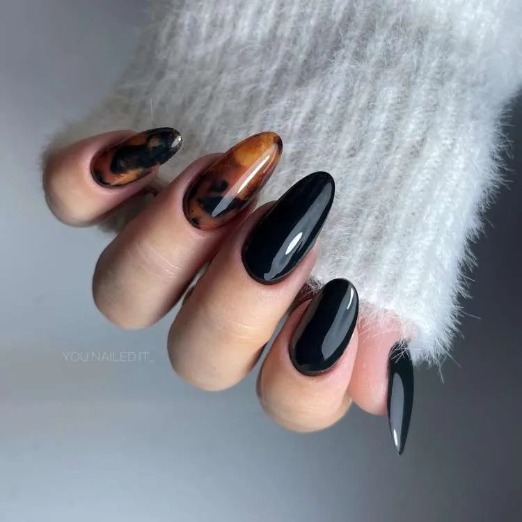 Unhas decoradas nas cores: preto e dourado/bege. Arte: mármore