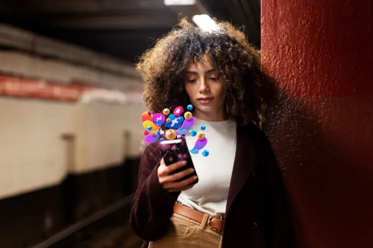 Mulher de pele negra mexendo no celular com montagem de ícones de redes sociais