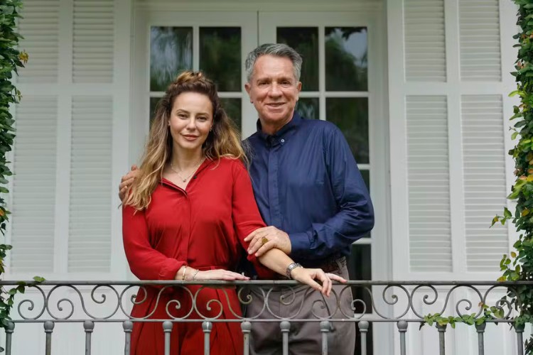 Paolla Oliveira (Heleninha) de look vermelho em sacada ao lado de Luís Salém (mordomo Eugênio)