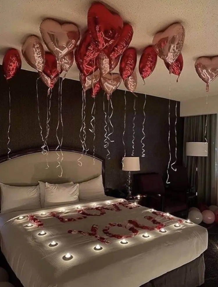 Quarto romântico com cama iluminada. Velas de mentira em cima da cama.