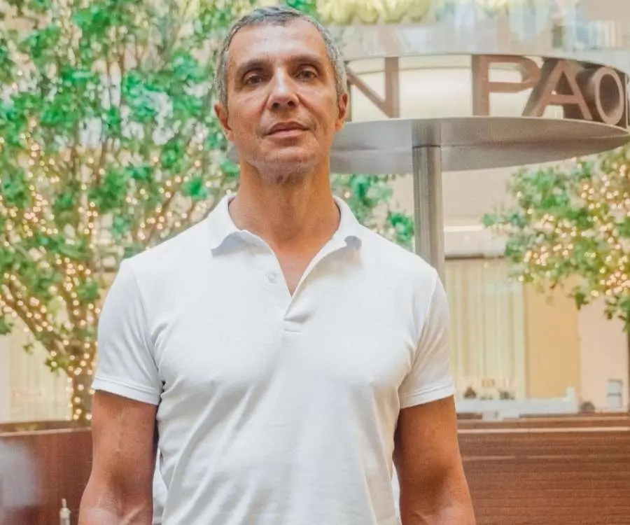 Foto de João Paulo Diniz usando camiseta polo branca.