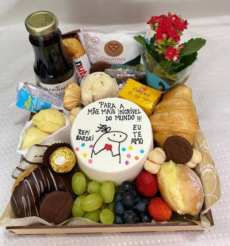 cesta para presentear, com bolo bentô, frutas, croassant, suco de uva, doces, pão de queijo e flor