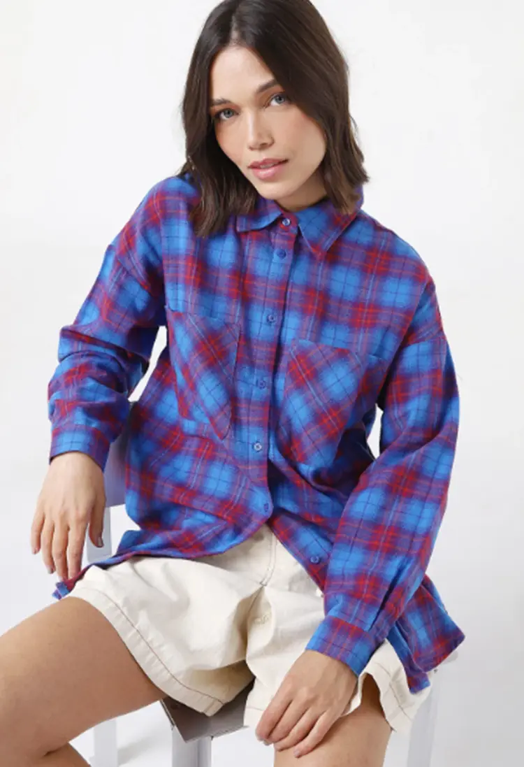 Mulher usando camisa xadrez vermelha e azul + short branco