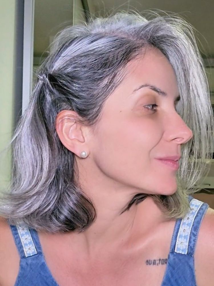 Mulher de pele clara com penteado lateral no cabelo curto branco