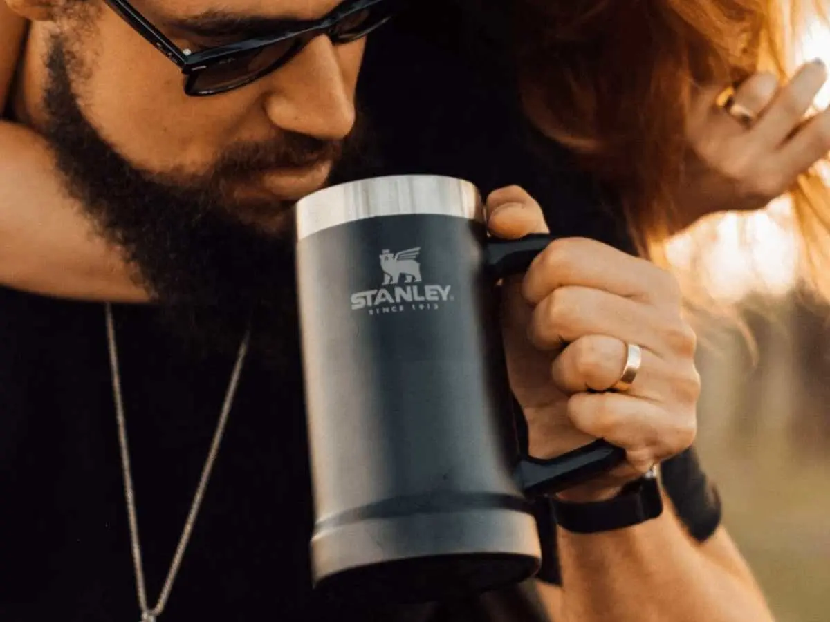 Foto de homem bebendo em Caneca térmica de cerveja Stanley.