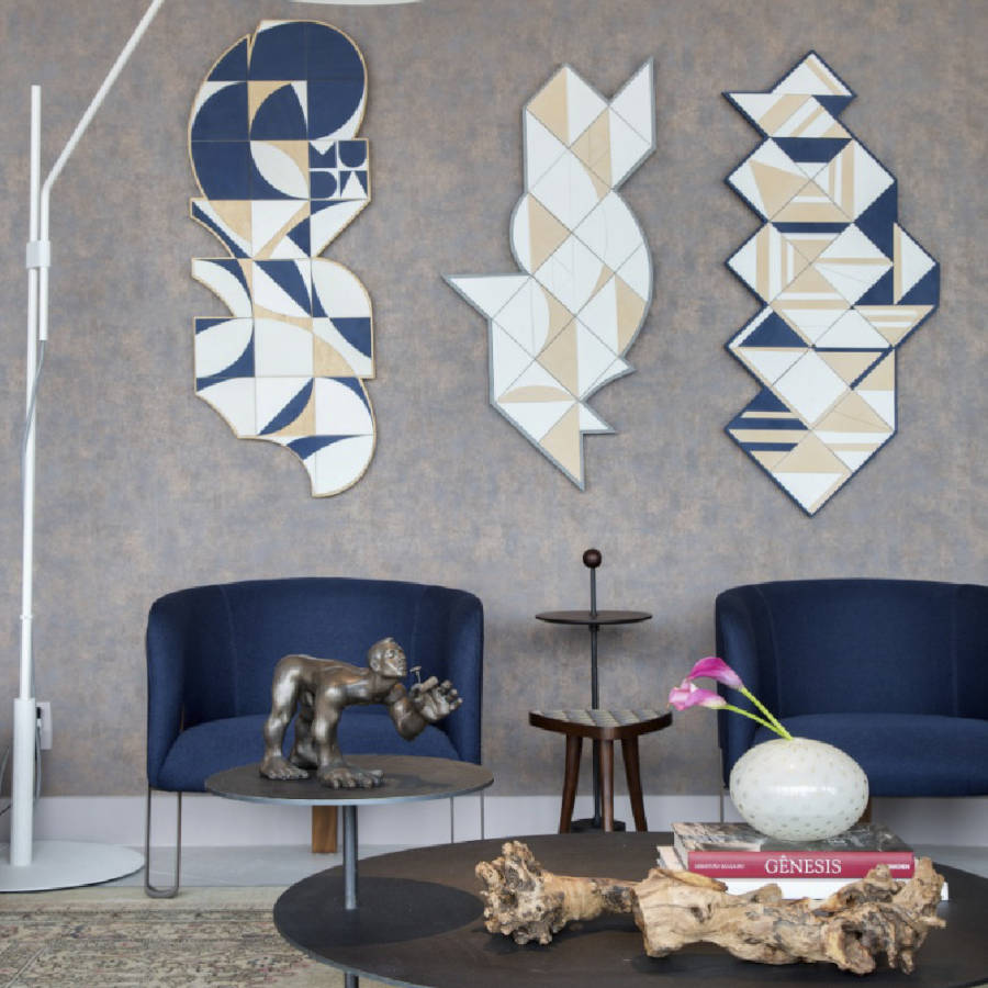 Sala de estar com poltronas e quadros azuis.